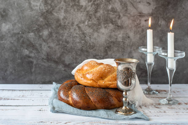 shabbat shalom-pain challah, vin de shabbat et bougies sur fond gris. avec espace de copie - challah jewish sabbath photography candle photos et images de collection