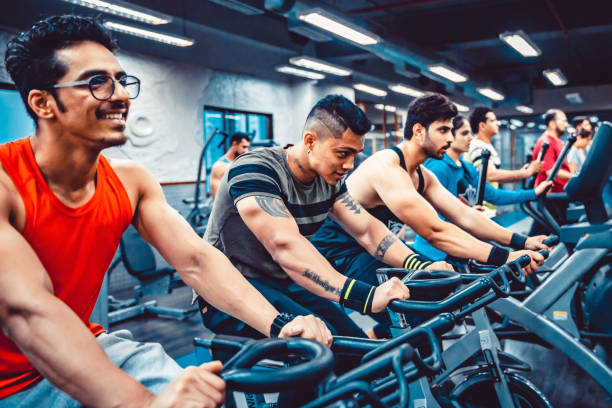 gruppo di persone che usano l'esercizio della bicicletta in un centro fitness - spinning instructor exercising gym foto e immagini stock