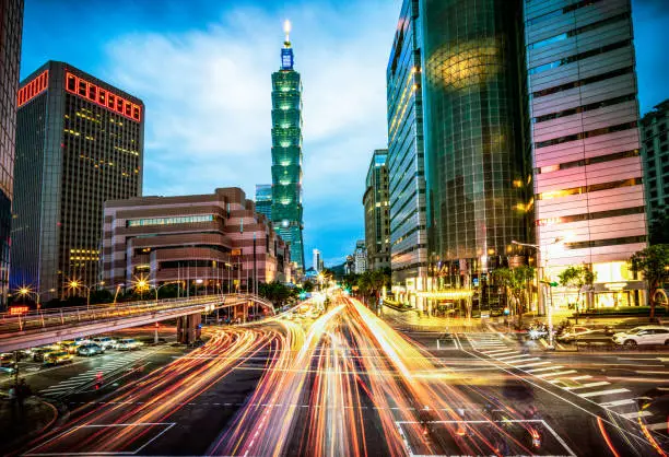 Motion blur on busy streets during rush hour at dusk in Taipei's city centre.