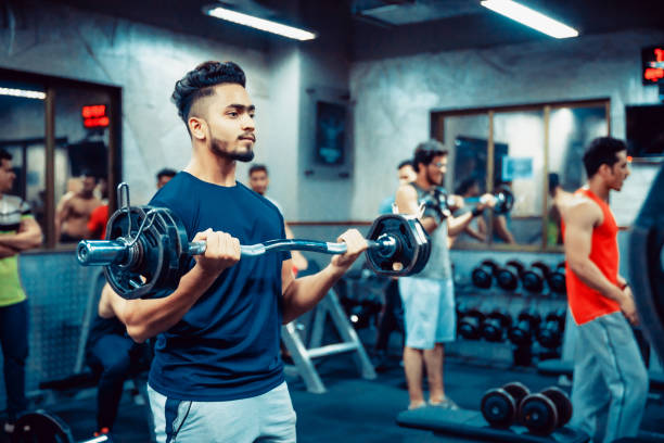 asiatischer erwachsener beim ausarbeiten im gym - bicep human arm macho flexing muscles stock-fotos und bilder