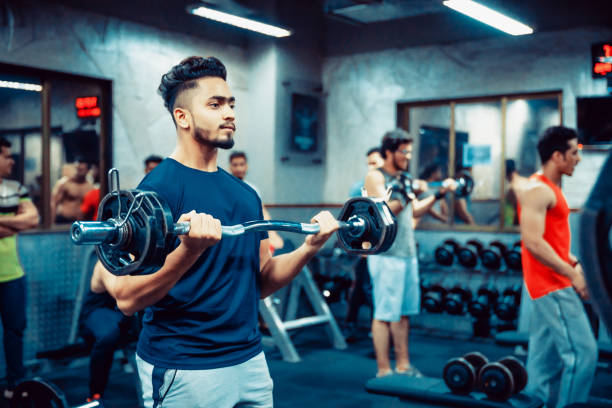Asian Adult Man working out at the Gym India, Fitness, Healthy Lifestyle - Indian man lifting weights at a fitness centre maharashtra photos stock pictures, royalty-free photos & images