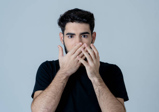 istock Young man feeling scared and shocked making fear anxiety gestures. Looking terrified and desperate trying to cover himself. Portrait with copy space. People and Human expressions and emotions. 1155232140