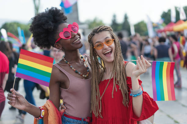 istock Happy young women walking with the pride parade 1155237447