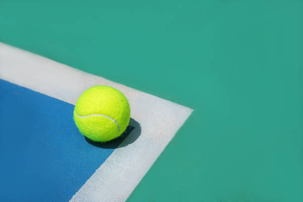 летняя спортивная концепция с теннисным мячом на белой линии на жестком теннисном корте. - tennis ball tennis ball white стоковые фото и изображения