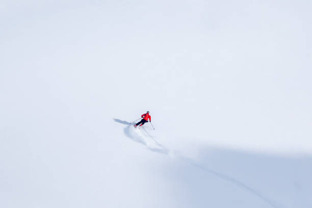 istock Single offpiste skier laying down first tracks on snow slope 1155237900