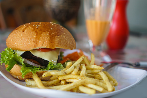 Burger and french fries on the table. Delicious food fast food. American food in a cafe