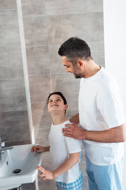 istock happy father hugging son in bathroom during morning routine 1155240537