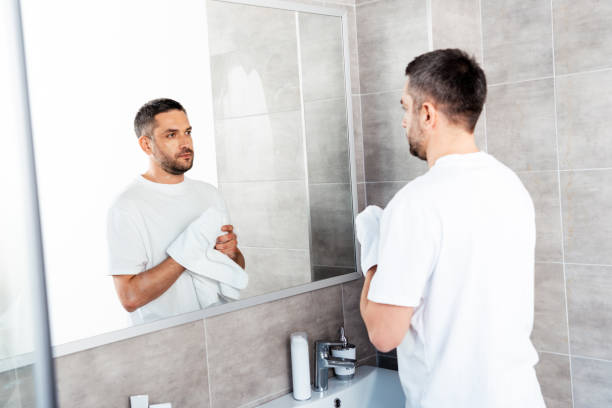 istock handsome man wiping hands with towel in bathroom during morning 1155240549