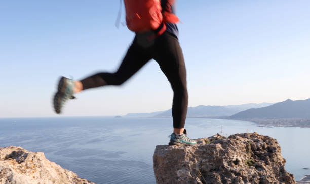 istock Female hiker jumps between rock summits 1155242271