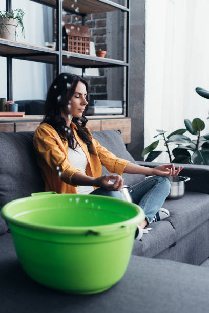istock Relaxed woman sitting on sofa in yoga pose 1155242502