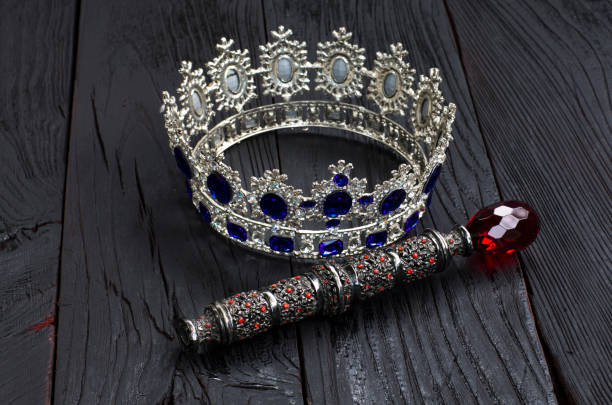royal crown and scepter on a black wooden background