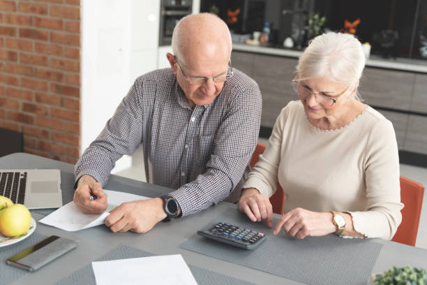 istock Senior couple paying bills together on laptop 1155244158