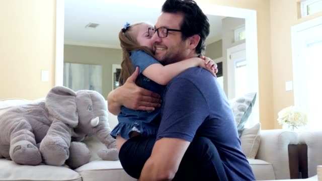 Loving dad hugs his young special needs daughter