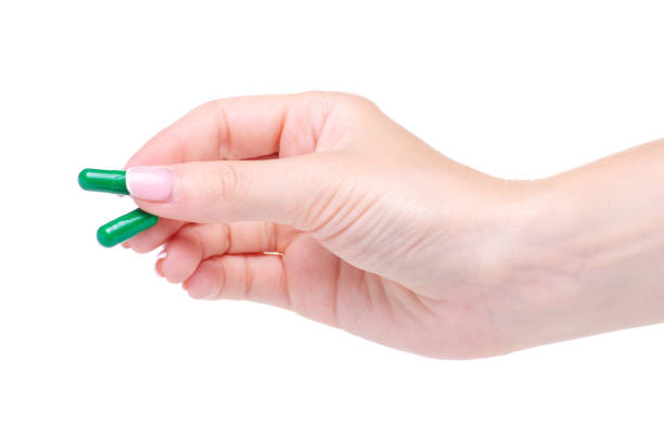 istock Green pills capcule medicine pharmasy in hand 1155254453