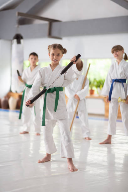 istock Girl in white kimono practicing with nunchucks 1155258513