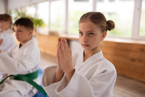 istock Appealing blonde girl learning aikido making Namaste sign 1155258578