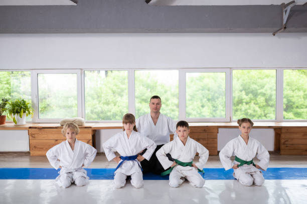 istock Trainer and pupils wearing white kimono sitting before training 1155258595