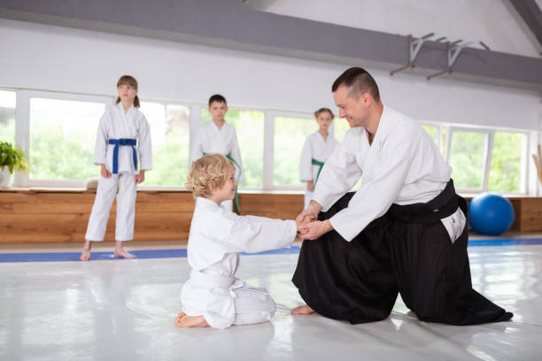 istock Beaming boy shaking hands of his aikido trainer and smiling 1155258606