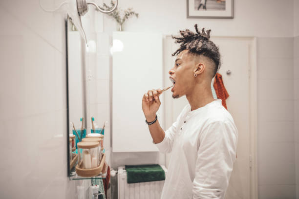 istock At home - young man brushing his teeth 1155258868