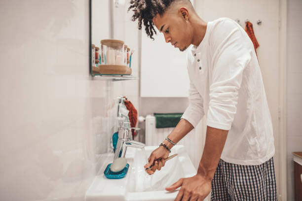 istock At home - young man brushing his teeth 1155259588
