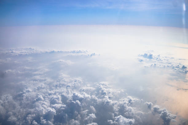 istock Airplane window overlooking the beautiful clouds and the earth. Sunset in flight on vacation. Tourist theme. Stock photo 1155259701