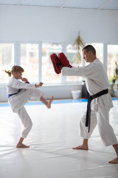 istock Helpful aikido trainer working with girl before competition 1155264058