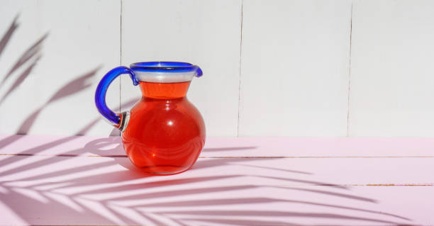 agua de hibisco en frasco de vidrio sobre fondo colorido - agua de jamaica fotografías e imágenes de stock