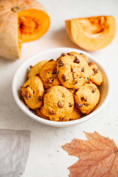 istock Pumpkin cookies with chocolate chips made from cake mix in a white ceramic bowl. 1155276994