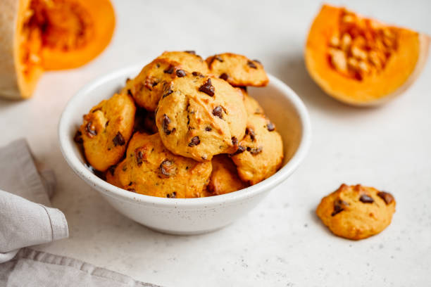 istock Pumpkin cookies with chocolate chips made from cake mix in a white ceramic bowl. 1155277027