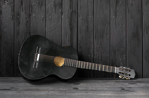 black guitar on a black wooden background