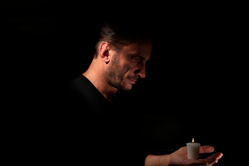 Man with Candle in black background