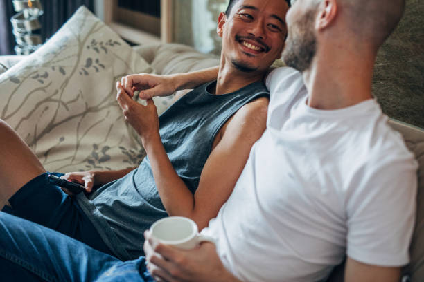 istock Homosexual couple relaxing at home 1155280340
