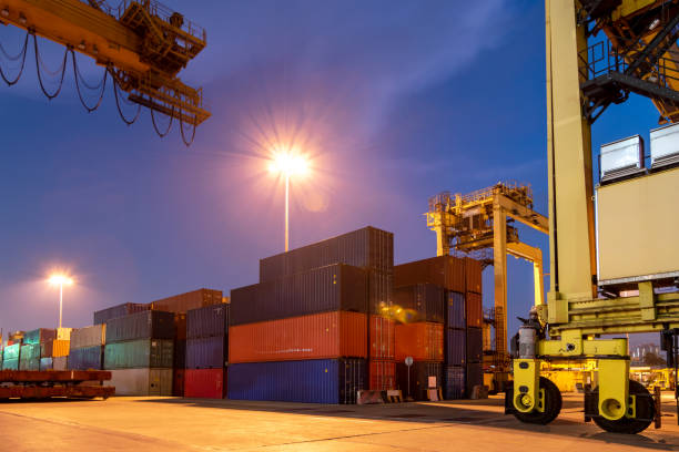 istock Logistics , transportation of Container Cargo freight ship with working crane bridge in shipyard. Smart logistic import export and transport industry concept with flare light. 1155281810
