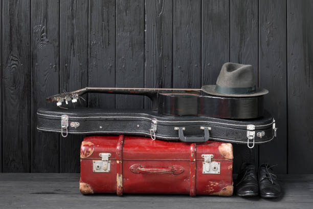 istock black guitar and a suitcase against a black wooden background 1155282294