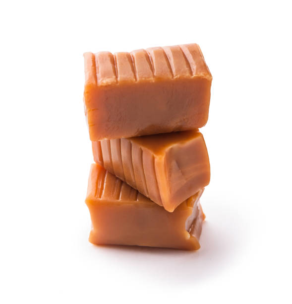 istock Caramels candy cubes stacked close-up arrangement isolated on white background 1155282332