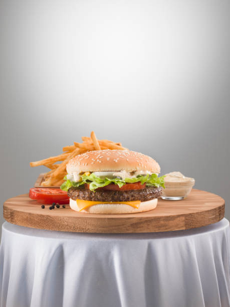 Cheese burger with french fries on wooden table.