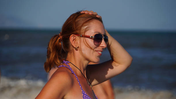 istock Beautiful woman in a eyeglasses on a beach 1155283245