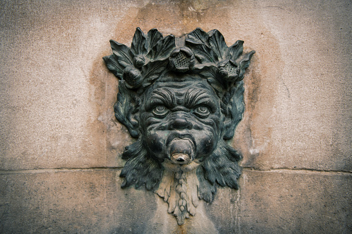 Grotesque or chimera carving on wall in Paris France