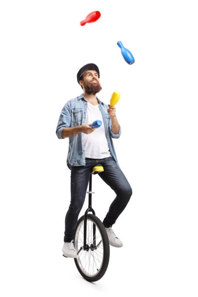 istock Bearded man on a unicycle juggling with clubs 1155287750