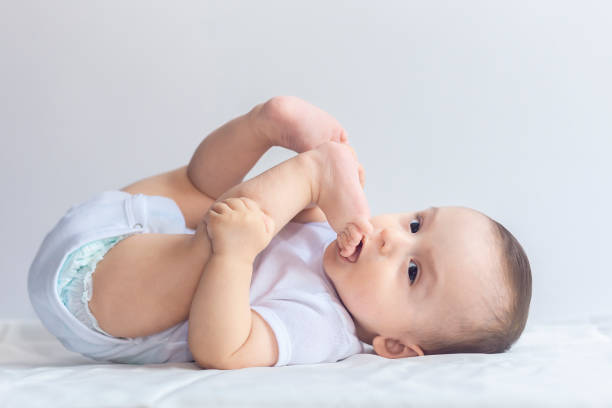 istock Little hungry baby having fun in white bedding 1155288983