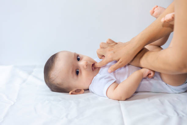 Baby boy teething pain Baby boy teething pain. Little 6-month baby having teeth pains. Mother rubbing gel to her little baby boy's teeth. Medicine and health concept. baby teeth stock pictures, royalty-free photos & images