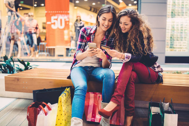 Mall shopping Smiling women shopping online with credit card clothing store credit card stock pictures, royalty-free photos & images