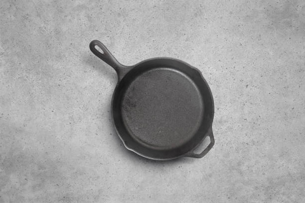 istock Cast iron frying pan on a cement background 1155291489