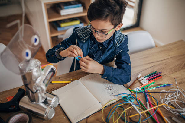 istock Intelligent schoolboy making recycled robot 1155292470