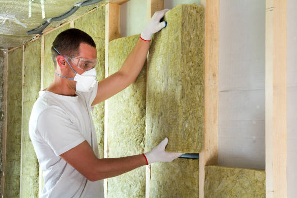 istock Worker in protective goggles and respirator insulating rock wool insulation in wooden frame for future house walls for cold barrier. Comfortable warm home, economy, construction and renovation concept 1155293480