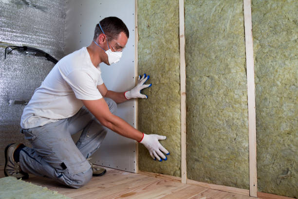 istock Worker in protective goggles and respirator insulating rock wool insulation in wooden frame for future house walls for cold barrier. Comfortable warm home, economy, construction and renovation concept 1155293492