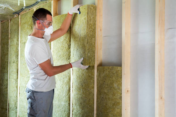 istock Worker in protective goggles and respirator insulating rock wool insulation in wooden frame for future house walls for cold barrier. Comfortable warm home, economy, construction and renovation concept 1155293550
