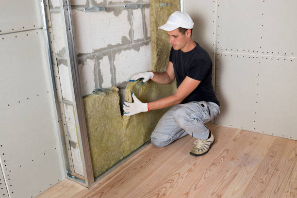 istock Worker in protective gloves insulating rock wool insulation in wooden frame for future house walls for cold barrier. Comfortable warm home, economy, construction and renovation concept 1155293556