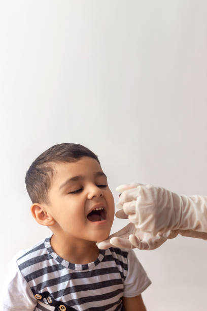 Little boy gets medicine from a little bottle stock photo