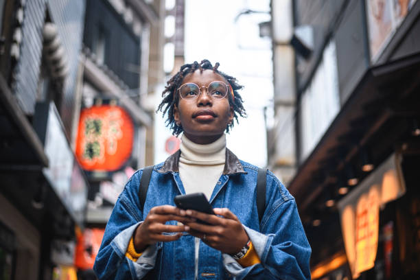 femme africaine avec le smartphone en vacances à tokyo - tourism telephone photos et images de collection